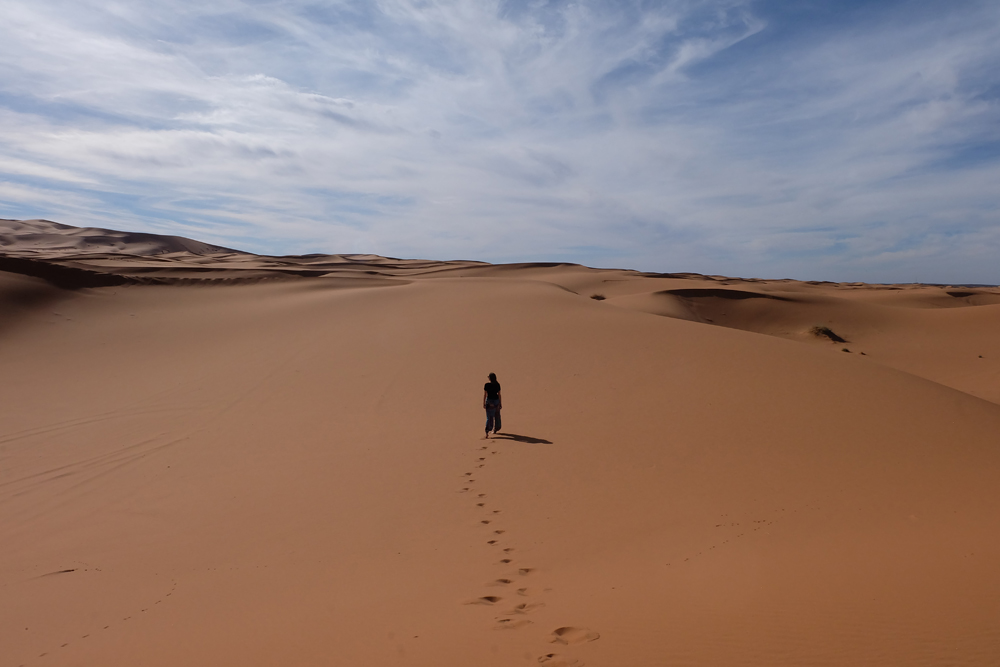 Girl standing in the middle of the Sahara Desert on a Morocco vacation