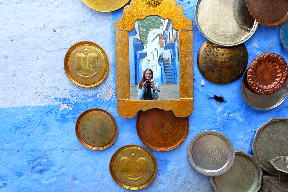 Girl taking photo in mirrors against a wall in Morocco.