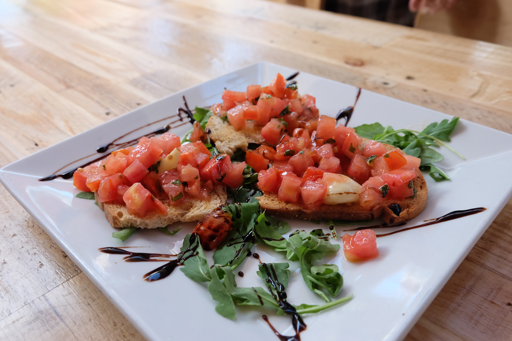 Bruschetta on a white plate with a balsamic drizzle. Enjoyed on my trip to San Francisco.