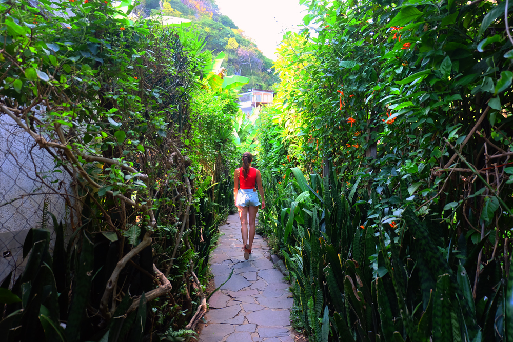 Lauren walking down a lush, green trail to the best place to stay in Lake Atitlan, Lush