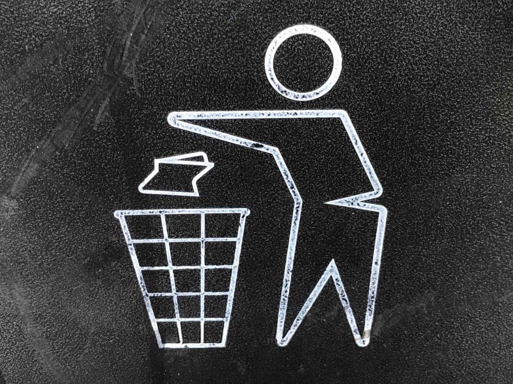 An illustration of a man throwing out garbage in a trashbin. 