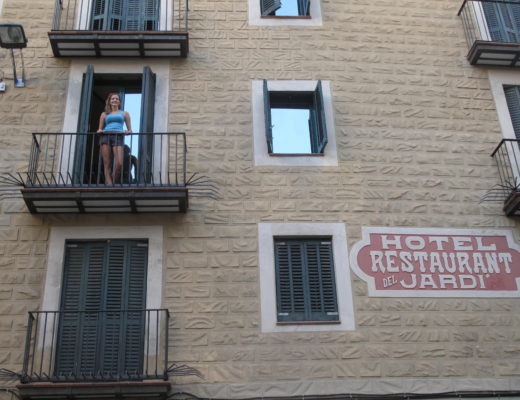 Girl standing on balcony at hotel in Barcelona, Spain