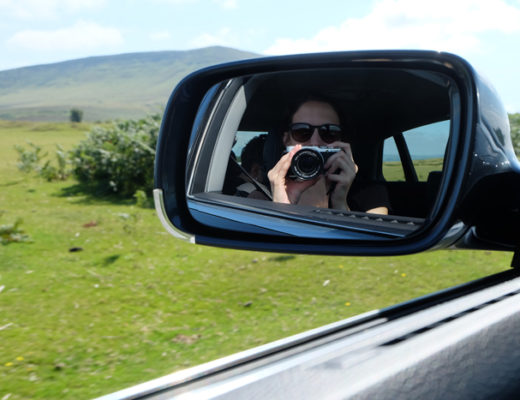 Girl in side mirror on car driving in rural Wales