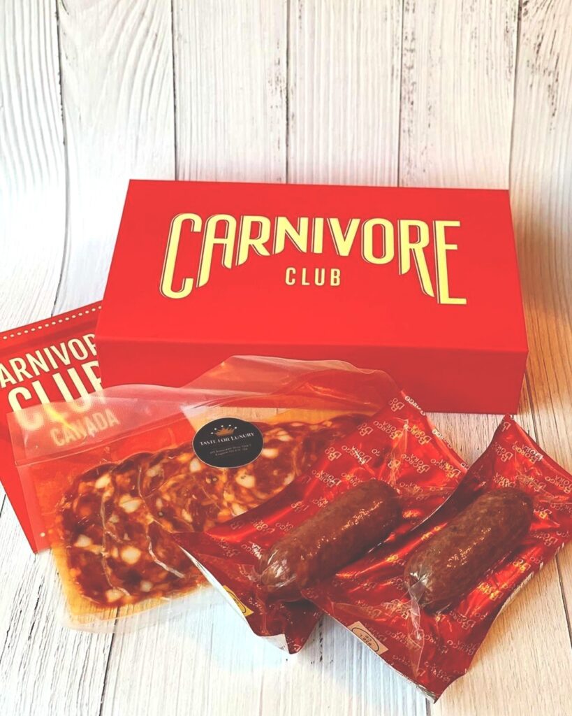 Carnivore Club subscription box with meat spread in front of it.